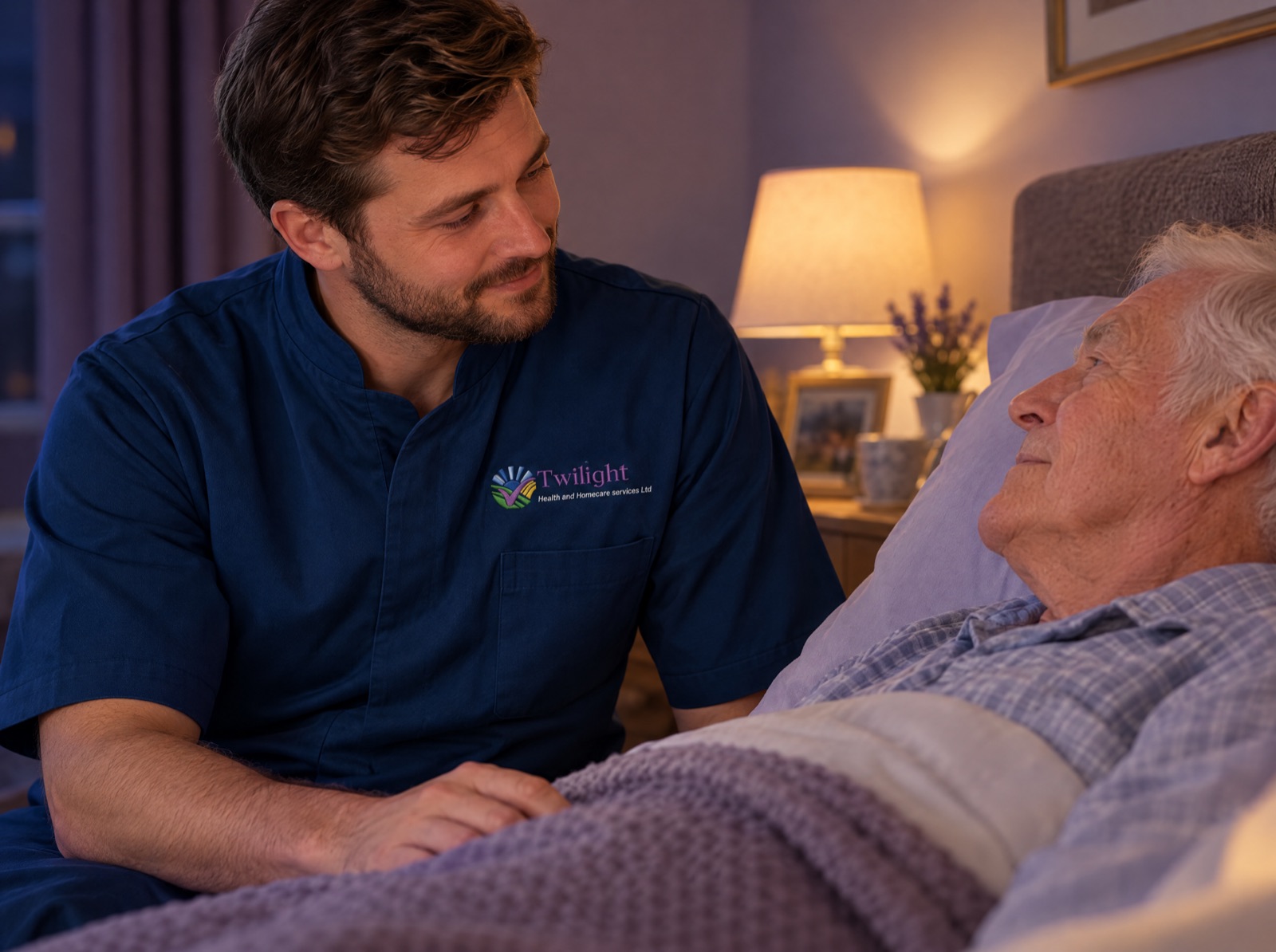 European heritage Twilight carer in a twilight-blue uniform reassuring an elderly man during overnight care at home
